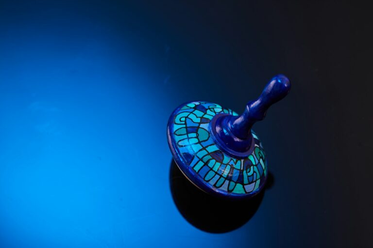 Jewish holiday Hanukkah with a wooden dreidel spinning top on a blue-black gradient background