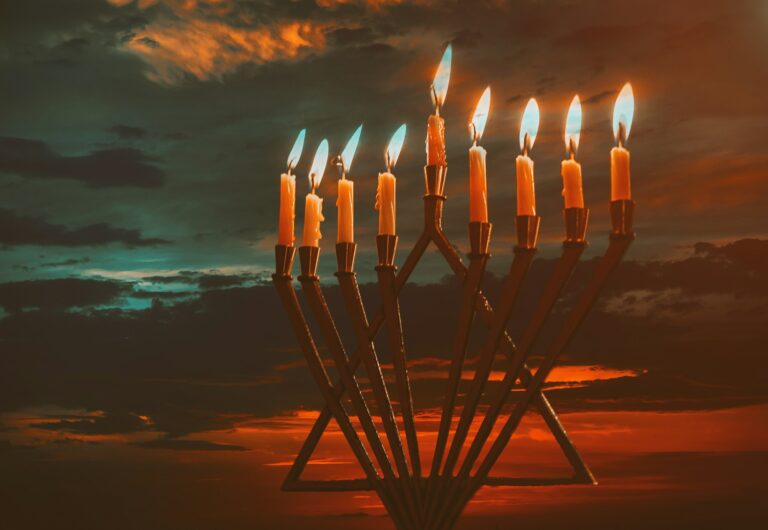 Jewish holiday Hanukkah with menorah traditional burning candles beautiful sunset sky in twilight