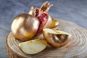 Rosh hashanah - jewish New Year holiday concept. Traditional symbols: Pomegranate and apple golden